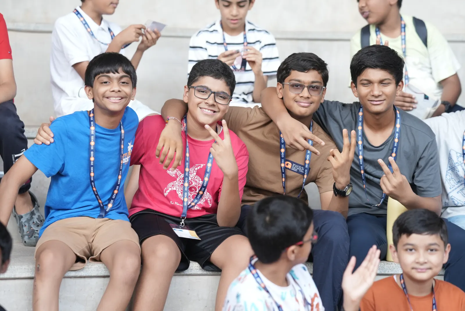A group of GenWise students sitting together on the steps, laughing