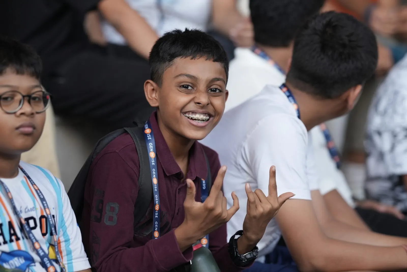 A GenWise student in a lanyard grinning at the camera